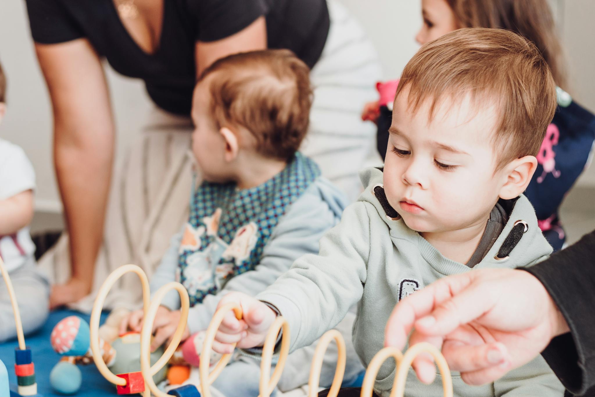 Group of young children playing with educational toys indoors, fostering learning and development.